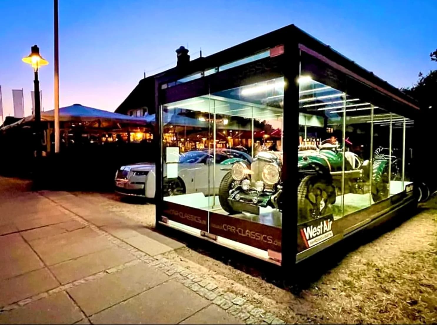 REINHART Gallery als Fahrzeug-Showroom bei Nacht, Oldtimer im Glasraum beleuchtet